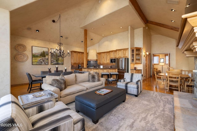 living area with a notable chandelier, wood finished floors, high vaulted ceiling, beamed ceiling, and baseboards