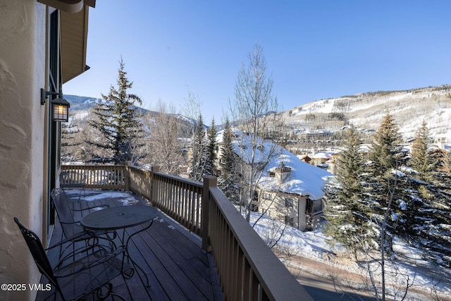 snow covered deck with a mountain view