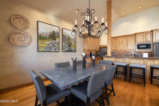 dining space featuring a notable chandelier, high vaulted ceiling, recessed lighting, and light wood-style floors