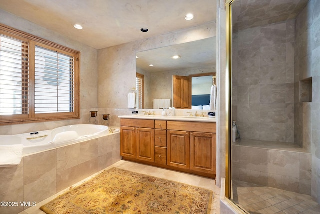 full bathroom with a garden tub, double vanity, a sink, a shower stall, and tile patterned floors