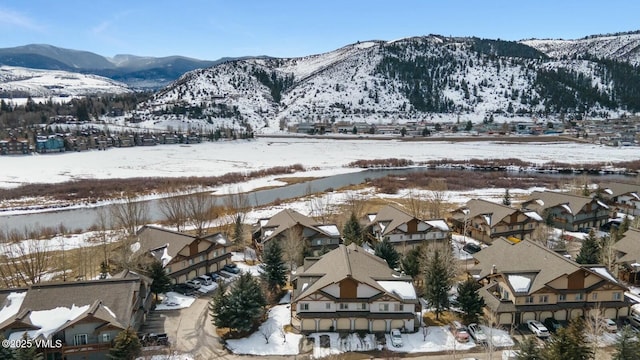 snowy aerial view featuring a residential view and a mountain view