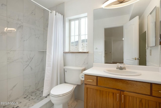 bathroom featuring vanity, toilet, and a tile shower