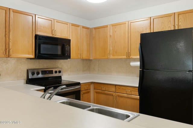 kitchen with black appliances, light countertops, and backsplash