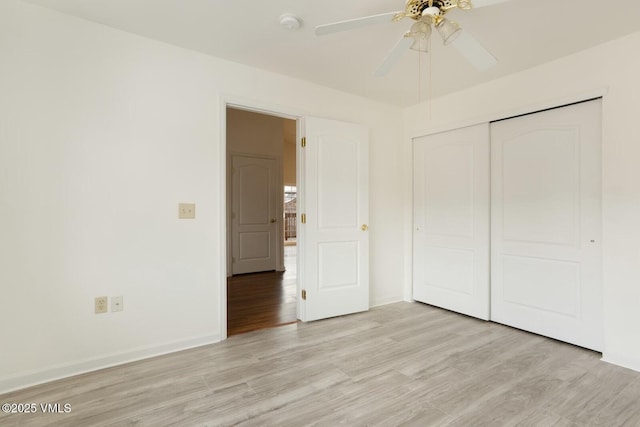 unfurnished bedroom with a closet, baseboards, light wood-style flooring, and a ceiling fan