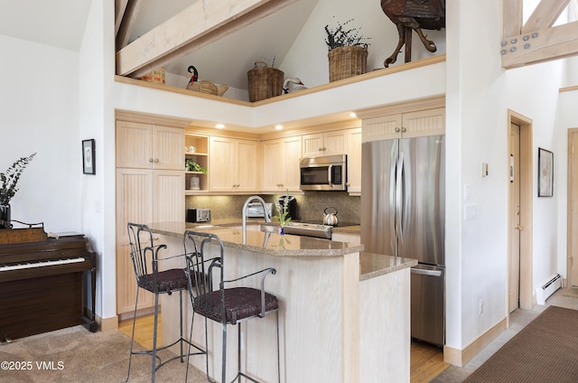 111 Scott Hill Rd Unit 17, Beaver Creek, CO 81620 - kitchen featuring appliances with stainless steel finishes, high vaulted ceiling, baseboard heating, open shelves, and light stone counters
