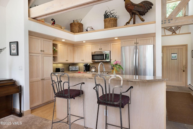 111 Scott Hill Rd Unit 17, Beaver Creek, CO 81620 - kitchen with stainless steel appliances, high vaulted ceiling, a kitchen bar, backsplash, and light stone counters