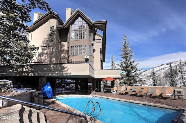 111 Scott Hill Rd Unit 17, Beaver Creek, CO 81620 - back of house with a chimney, a patio area, and a mountain view