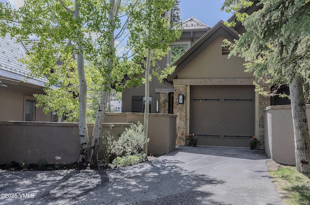 111 Scott Hill Rd Unit 17, Beaver Creek, CO 81620 - view of front of property with driveway, stone siding, and an attached garage