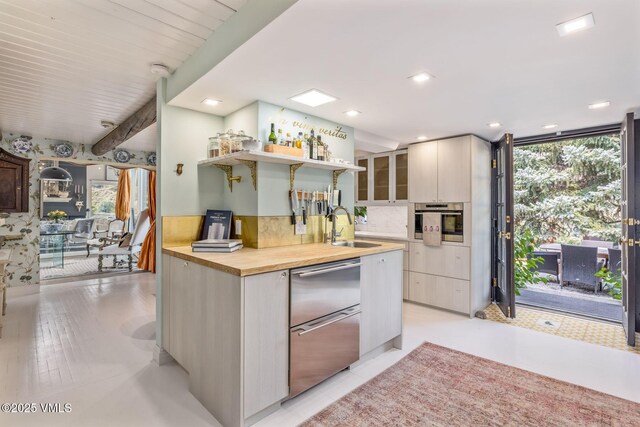 kitchen featuring tasteful backsplash, sink, stainless steel oven, and a wall of windows