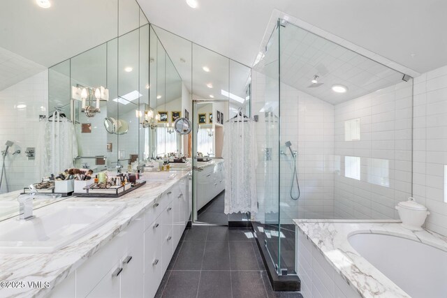 bathroom with plus walk in shower, lofted ceiling, tile walls, and tile patterned floors