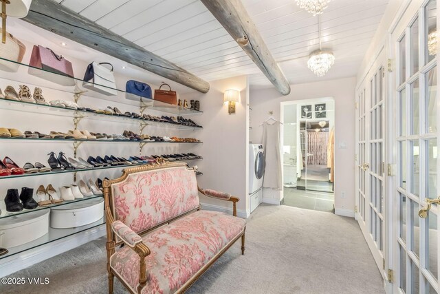 sitting room with beam ceiling, independent washer and dryer, carpet flooring, french doors, and a chandelier