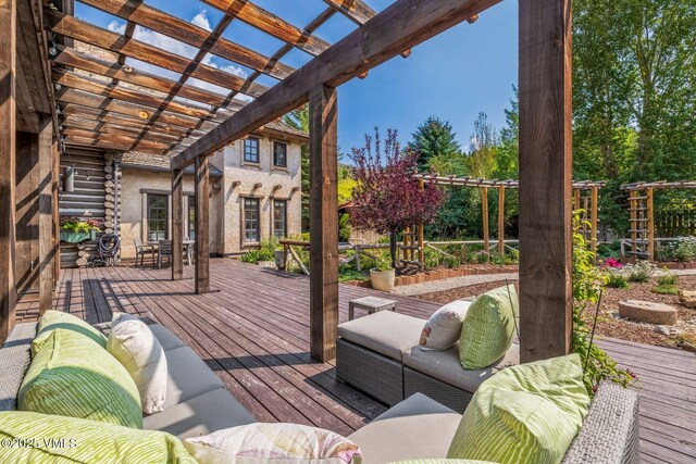 wooden deck with an outdoor hangout area and a pergola