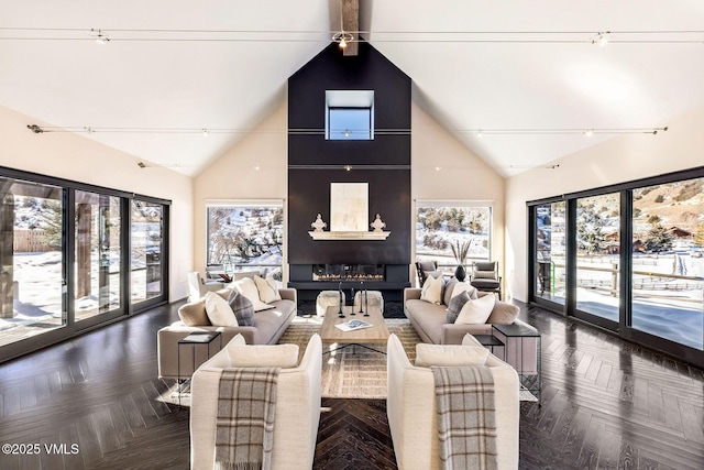 living room featuring a large fireplace, high vaulted ceiling, dark parquet floors, and a wealth of natural light