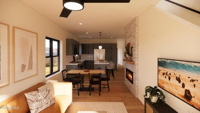 dining space featuring a stone fireplace and light hardwood / wood-style floors