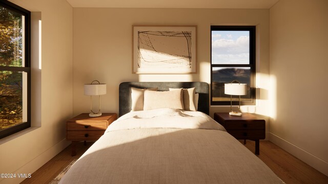 bedroom with multiple windows and hardwood / wood-style floors