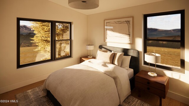 bedroom with multiple windows, hardwood / wood-style floors, and vaulted ceiling