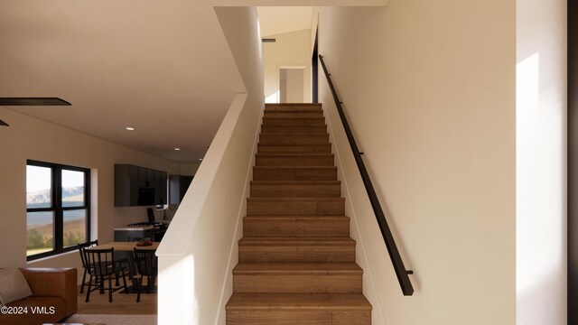 staircase with hardwood / wood-style floors and ceiling fan