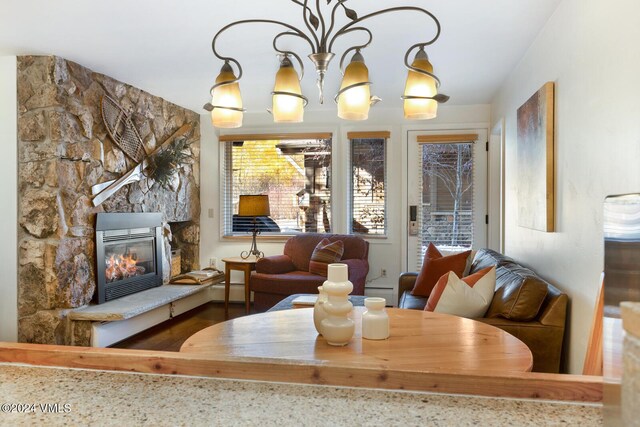 interior space featuring a stone fireplace and an inviting chandelier