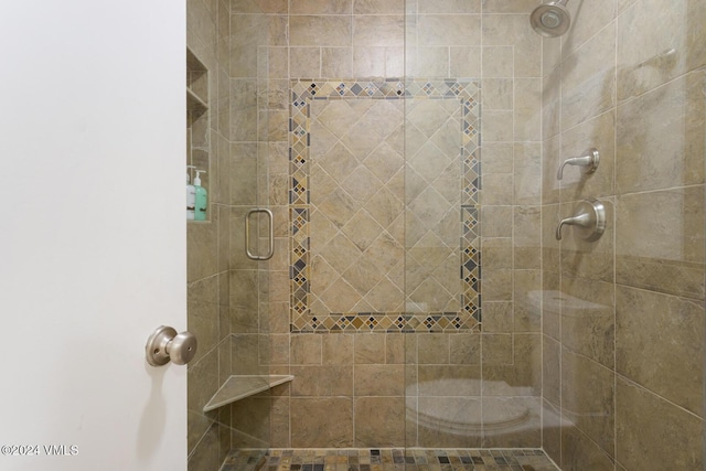 bathroom featuring a shower with shower door