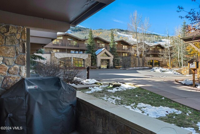 snow covered patio featuring area for grilling and a mountain view