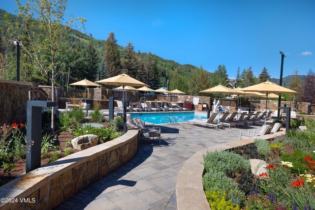 view of pool with a mountain view and a patio area