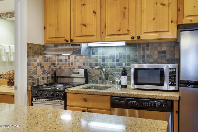 kitchen featuring sink, decorative backsplash, stainless steel appliances, and light stone countertops