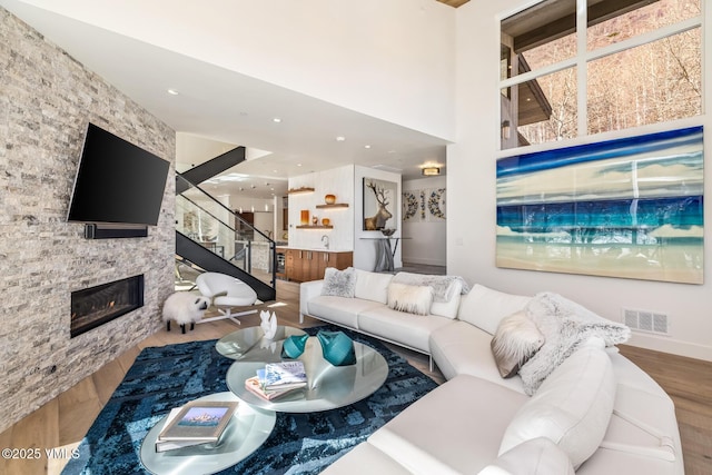 3235 Katsos Ranch Rd, Vail, CO 81657 - living room with a fireplace, wood finished floors, stairway, and a high ceiling