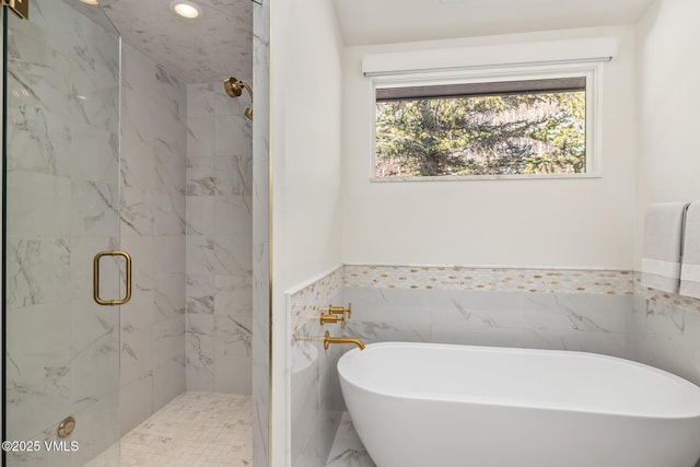 3235 Katsos Ranch Rd, Vail, CO 81657 - full bathroom with healthy amount of natural light, a marble finish shower, a freestanding bath, a wainscoted wall, and tile walls