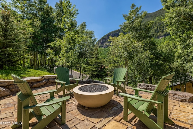 3235 Katsos Ranch Rd, Vail, CO 81657 - view of patio / terrace with a fire pit, a mountain view, and a forest view