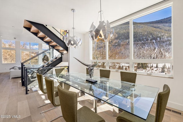 3235 Katsos Ranch Rd, Vail, CO 81657 - dining room featuring a chandelier, wood finished floors, and a mountain view