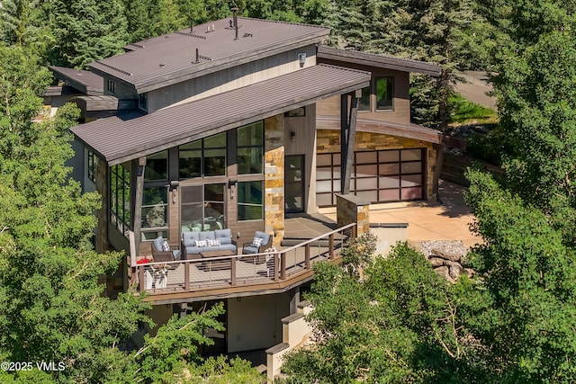 3235 Katsos Ranch Rd, Vail, CO 81657 - rear view of house with an outdoor hangout area, driveway, a metal roof, a standing seam roof, and a wooden deck