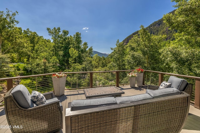 3235 Katsos Ranch Rd, Vail, CO 81657 - wooden terrace featuring outdoor lounge area, a view of trees, and a mountain view