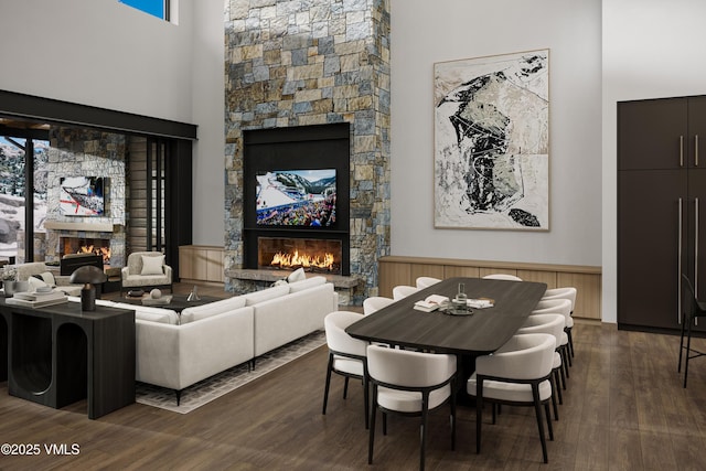 46 Red Spruce Ln Unit 2, Beaver Creek, CO 81620 - living room with a stone fireplace, a high ceiling, dark wood-style flooring, and a wainscoted wall