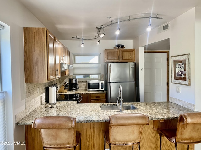 34323 US Highway 6 Unit R-201, Edwards, CO 81632 - kitchen featuring stainless steel appliances, a sink, a peninsula, and light stone counters