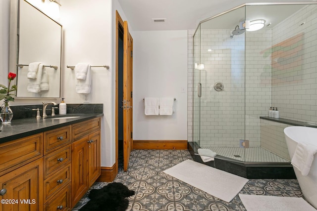 bathroom with tile patterned flooring, vanity, and walk in shower