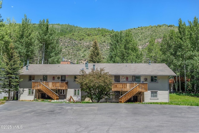 2783 Kinnikinnick Rd Unit 7, Vail, CO 81657 - ranch-style home featuring stairway, a forest view, a deck, and a chimney