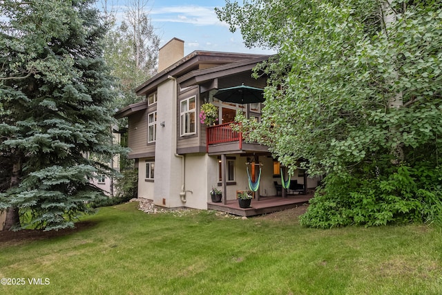 2832 Kinnickinnick Rd Unit 4, Vail, CO 81657 - rear view of property with a chimney, a lawn, and stucco siding