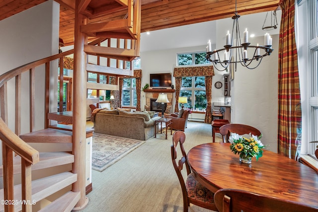 2832 Kinnickinnick Rd Unit 4, Vail, CO 81657 - dining room with a chandelier, stairs, carpet floors, a high ceiling, and a glass covered fireplace
