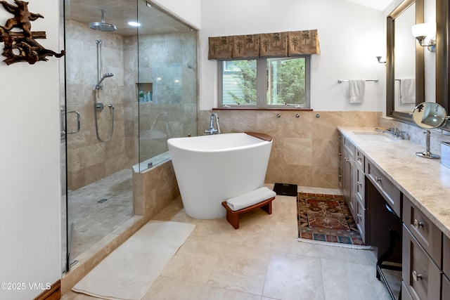 2832 Kinnickinnick Rd Unit 4, Vail, CO 81657 - bathroom with a stall shower, a soaking tub, vanity, tile walls, and tile patterned flooring