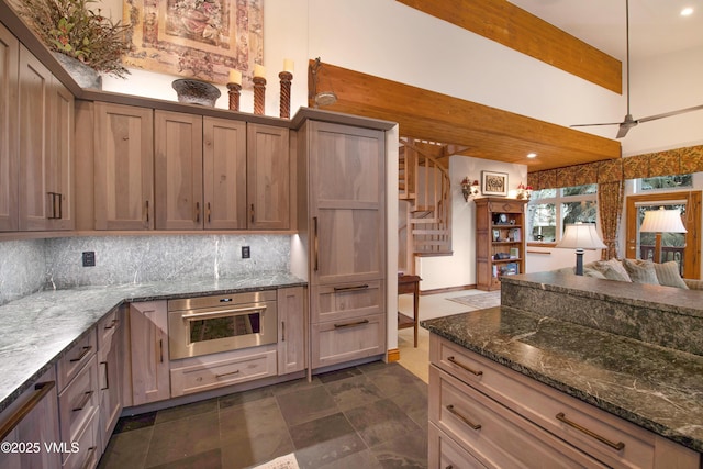 2832 Kinnickinnick Rd Unit 4, Vail, CO 81657 - kitchen featuring oven, backsplash, open floor plan, dark stone countertops, and a ceiling fan
