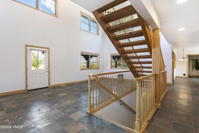 foyer entrance featuring an inviting chandelier and a towering ceiling