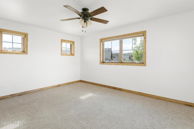 carpeted empty room featuring plenty of natural light and ceiling fan