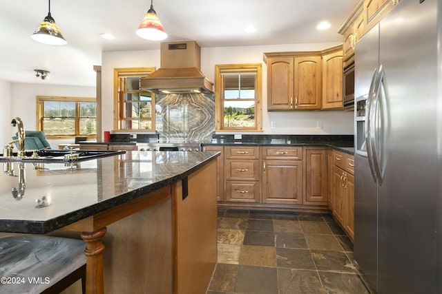 kitchen featuring a healthy amount of sunlight, appliances with stainless steel finishes, custom range hood, and decorative light fixtures