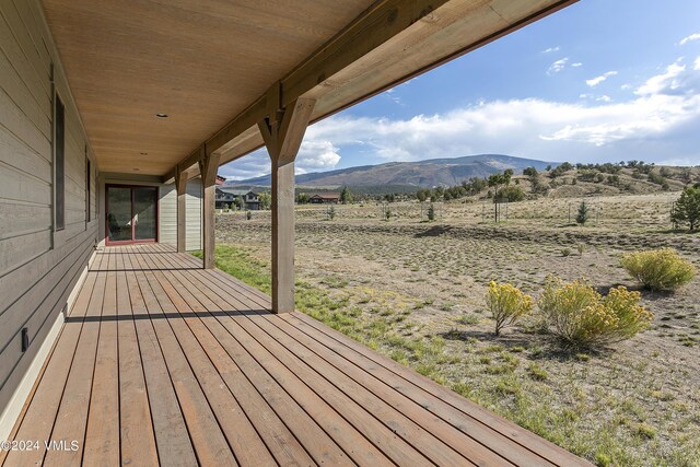 deck with a rural view and a mountain view