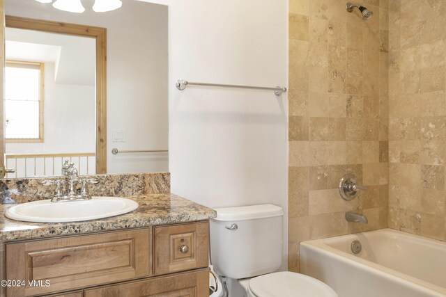 full bathroom with tiled shower / bath, vanity, and toilet