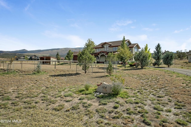 view of yard with a rural view and a mountain view