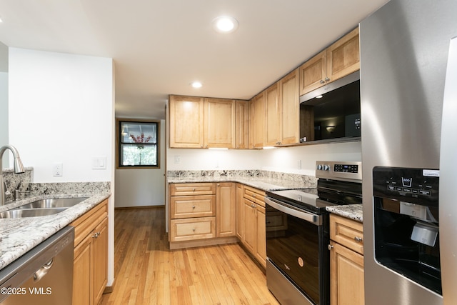 717 Bull Run Unit A, Eagle, CO 81631 - kitchen featuring appliances with stainless steel finishes, light wood-style floors, light brown cabinets, recessed lighting, and light stone countertops