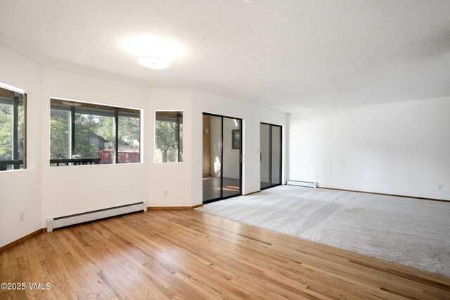 717 Bull Run Unit A, Eagle, CO 81631 - empty room featuring a baseboard heating unit, a textured ceiling, and wood finished floors