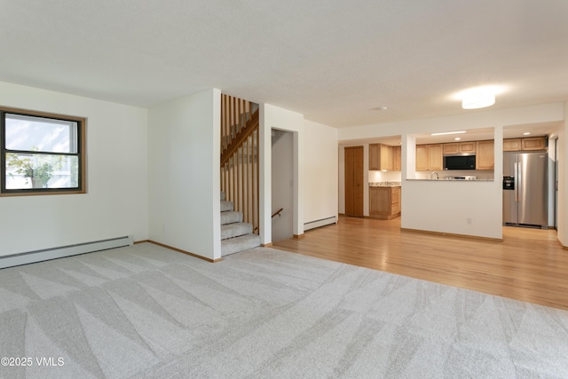 717 Bull Run Unit A, Eagle, CO 81631 - unfurnished living room featuring light colored carpet, a baseboard radiator, stairway, and baseboard heating