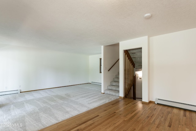717 Bull Run Unit A, Eagle, CO 81631 - unfurnished room with baseboard heating, stairs, a smoke detector, wood finished floors, and a textured ceiling